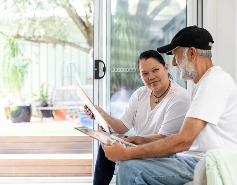 Woman and Elderly Man Examining Some Documents