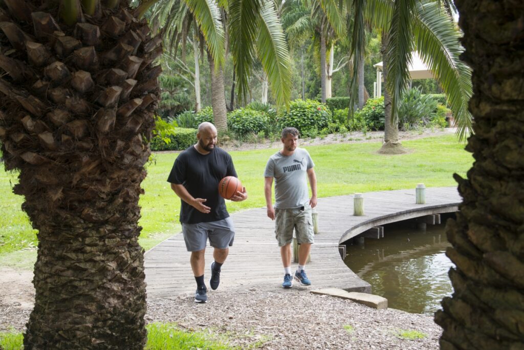 Two Men Walking with a Basketball in Hand